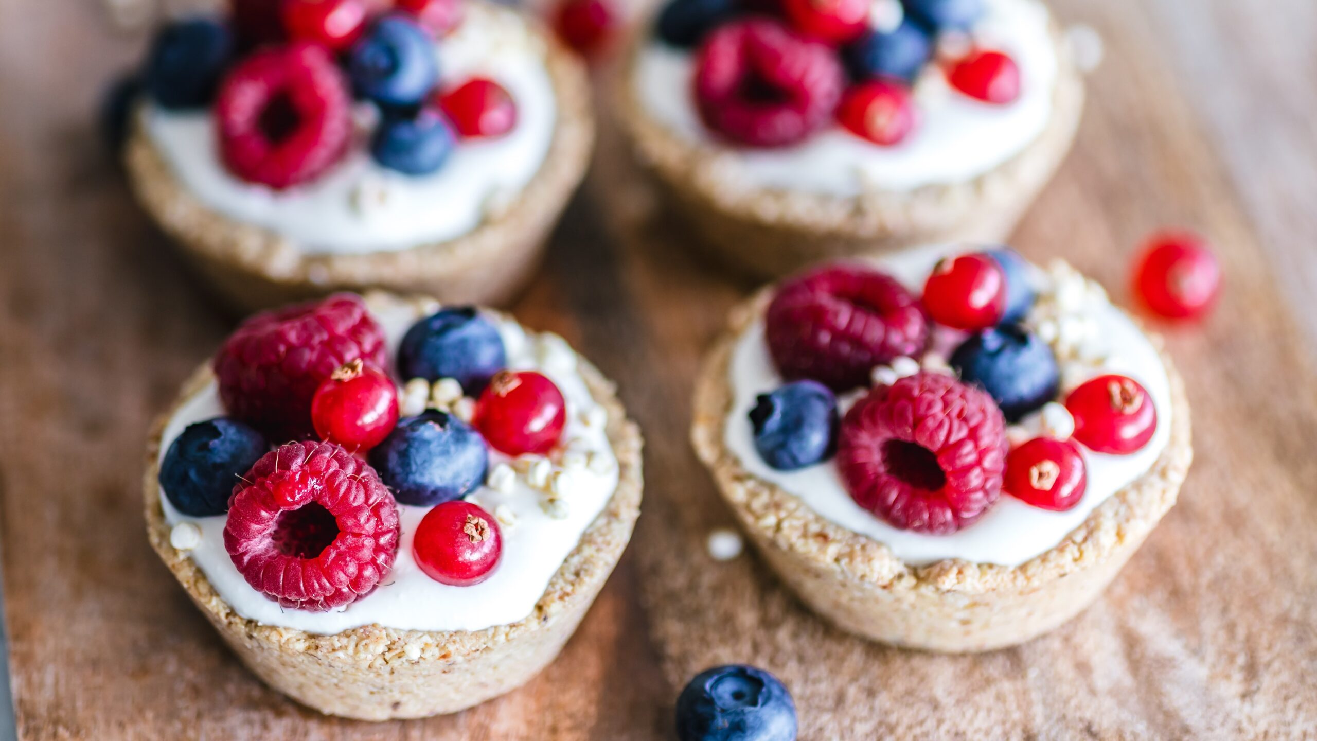 A chopping board with baked oats. The baked oats are covered in yoghurt and berries.