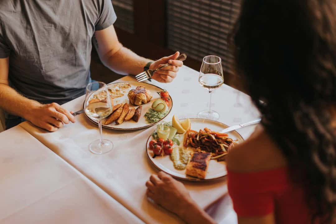 Two people enjoying a gluten free meal at a table, most likely on a date, to give an example of the gluten free dating experience.